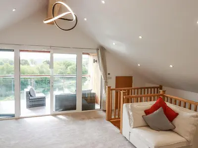 a living room with a couch and a large window at Carnon Gwel, Devoran in Truro