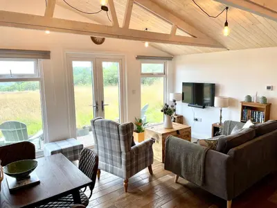 a living room with a couch and a table at Willow Lodge in Helston