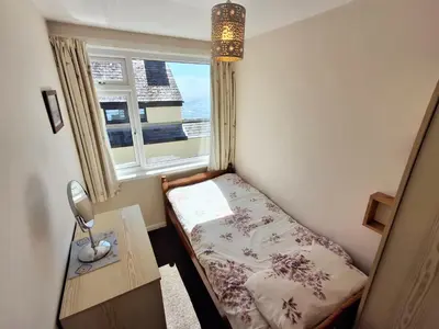 a small bedroom with a bed and a window at Loe Bar Bottom in Porthleven