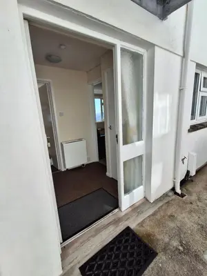 an open door into a room with a carpet at Loe Bar Bottom in Porthleven