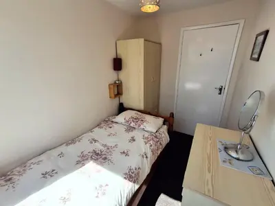 a small bedroom with a bed and a desk at Loe Bar Bottom in Porthleven
