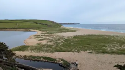 an aerial view of a beach and the ocean at Loe Bar Bottom in Porthleven