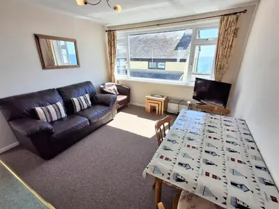 a living room with a couch and a table at Loe Bar Bottom in Porthleven