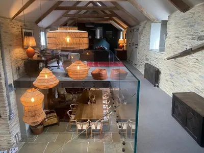 a room with a table and chairs and some lamps at Tregrylls Barton in Boscastle