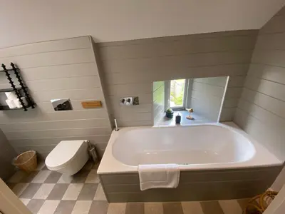 a bathroom with a large tub and a toilet at Tregrylls Barton in Boscastle