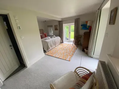 a bedroom with a bed and a living room at Tregrylls Barton in Boscastle