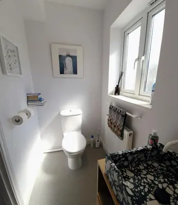 a white bathroom with a toilet and a window at Cosy house on a quiet estate in Truro in Truro