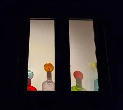 a window with four different colored glass bottles at Cosy house on a quiet estate in Truro in Truro
