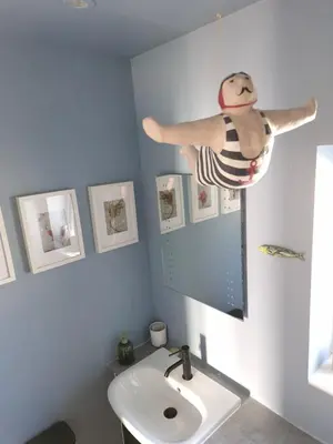 a woman in a swimsuit hanging above a sink in a bathroom at Cosy house on a quiet estate in Truro in Truro