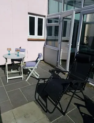 two chairs and a table on a patio at Cosy house on a quiet estate in Truro in Truro