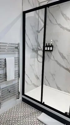 a bathroom with a shower with a glass door at St Mary's Mews in Truro