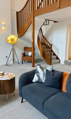 a living room with a blue couch and a staircase at St Mary's Mews in Truro