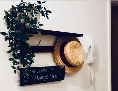 a hat and a sign hanging on a wall at St Mary's Mews in Truro