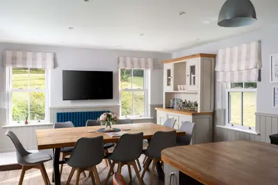 a dining room with a table and chairs at Beautiful Country Farmhouse Set In A Stunning Woodland With Pool, Sauna & Parking at 'The Old Farmhouse' in Ponsanooth