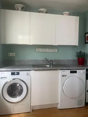 a kitchen with a washing machine and a sink at Cosy 1 bed apartment near Crantock beach in Crantock
