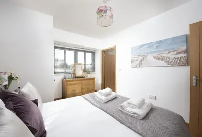 a bedroom with a bed with two towels on it at Hob Nob in Liskeard