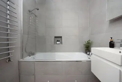 a white bathroom with a tub and a sink at Hob Nob in Liskeard