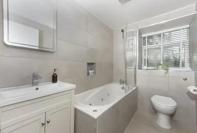 a bathroom with a tub and a toilet and a sink at Rainbow Cottage in Liskeard