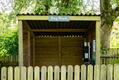 a dog gate with a sign that reads dog wash at Rainbow Cottage in Liskeard