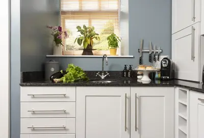a kitchen with white cabinets and a sink at Honey Pot in Liskeard