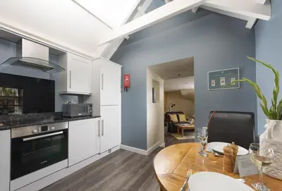 a kitchen and dining room with a wooden table at Honey Pot in Liskeard
