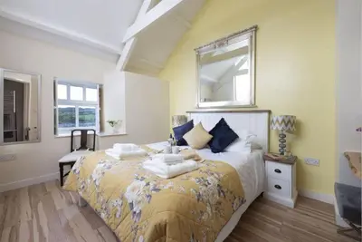 a bedroom with a large bed with a mirror on it at Honey Pot in Liskeard