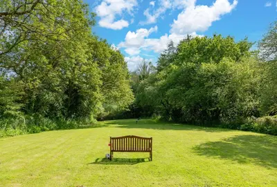 a park bench sitting in the middle of a field at Spice Barn in Liskeard
