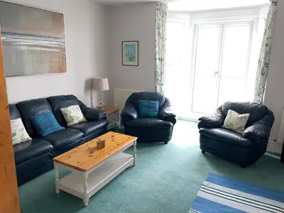 a living room with two couches and a coffee table at Atlantic View, North Cornwall seafront, 5* Gold in Polzeath