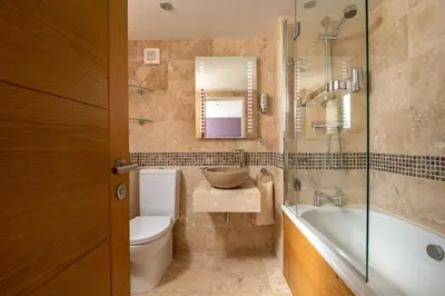 a bathroom with a tub and a toilet and a sink at Atlantic View Coach House, North Cornwall seafront, 5 star Gold in Polzeath