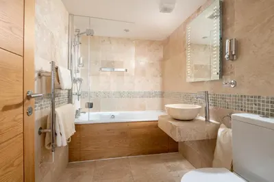 a bathroom with a tub and a sink and a toilet at Atlantic View Coach House, North Cornwall seafront, 5 star Gold in Polzeath