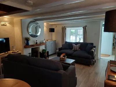 a living room with a couch and a table at Cosy Traditional Cornish Cottage in Tregoney