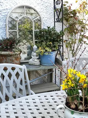 a table with two chairs and some plants on it at Cosy Traditional Cornish Cottage in Tregoney