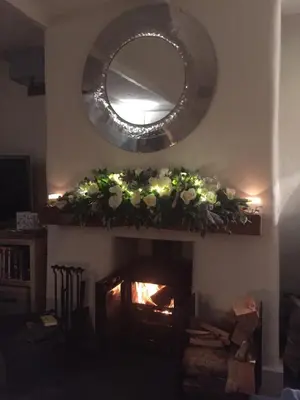 a living room with a fireplace with a mirror at Cosy Traditional Cornish Cottage in Tregoney