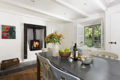 a dining room with a table and a fireplace at Worvas Counthouse - Country Cottage - Hot Tub - Pet Friendly in St Ives