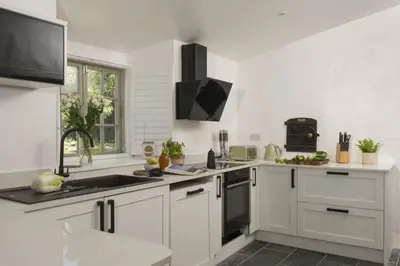 a white kitchen with a sink and a stove at Worvas Counthouse - Country Cottage - Hot Tub - Pet Friendly in St Ives