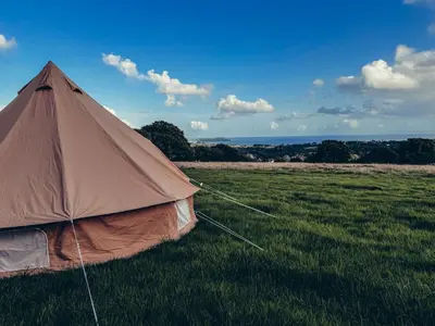 a tent sitting in a field of grass at Furnished Bell Tent 1 in St Austell
