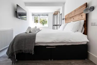 a bedroom with a large bed with a wooden headboard at Another Nook in St Ives