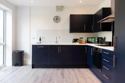 a kitchen with blue cabinets and a sink at Another Nook in St Ives