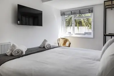 a bedroom with a large white bed with towels on it at Another Nook in St Ives