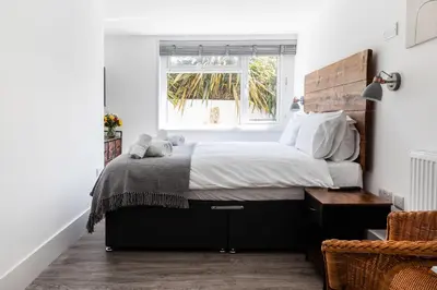 a bedroom with a large bed and a window at Another Nook in St Ives