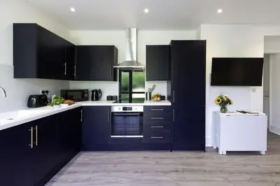 a kitchen with blue cabinets and a white refrigerator at Another Nook in St Ives