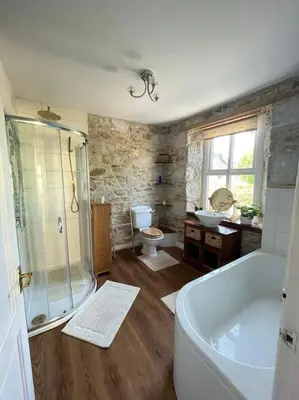a bathroom with a tub and a shower and a toilet at Open Plan 3 Bedrooms Cornish stone house cottage in St Austell
