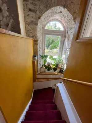 a staircase in a room with a window at Open Plan 3 Bedrooms Cornish stone house cottage in St Austell
