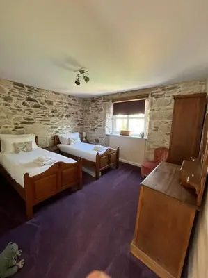 a large room with two beds and a window at Open Plan 3 Bedrooms Cornish stone house cottage in St Austell