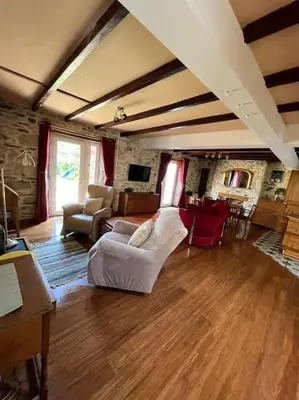 a living room with a white chair and a couch at Open Plan 3 Bedrooms Cornish stone house cottage in St Austell