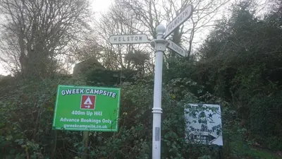 a street sign with a sign for theover camassic and a sign for at Tiny House Glamping, sleeps up to 6 in Gweek