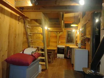 a room with a staircase in a log cabin at Tiny House Glamping, sleeps up to 6 in Gweek