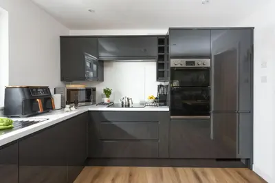 a kitchen with black cabinets and white counter tops at Tre Lowen, Goonhavern, Perranporth - Free Parking - Free Wifi - Games Room in Perranporth