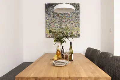 a dining room table with a painting on the wall at Tre Lowen, Goonhavern, Perranporth - Free Parking - Free Wifi - Games Room in Perranporth