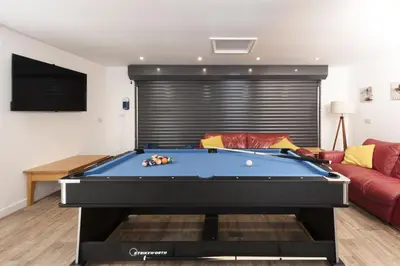 a pool table in a living room with a red couch at Tre Lowen, Goonhavern, Perranporth - Free Parking - Free Wifi - Games Room in Perranporth